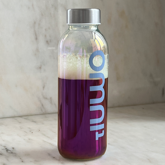 Glass Bottle With Dark Purple Liquid Inside